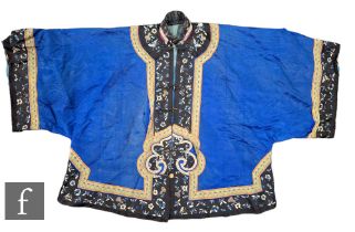 A Chinese late Qing Dynasty embroidered silk short jacket, the blue ground, edged with embroidered