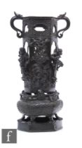 A Chinese late Qing Dynasty cast metal censer, raised on a hexagonal base with pierced sides adorned