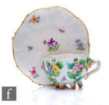 A 19th Century Meissen cabinet cup and saucer, the fluted cup with rustic cross handle and raised to