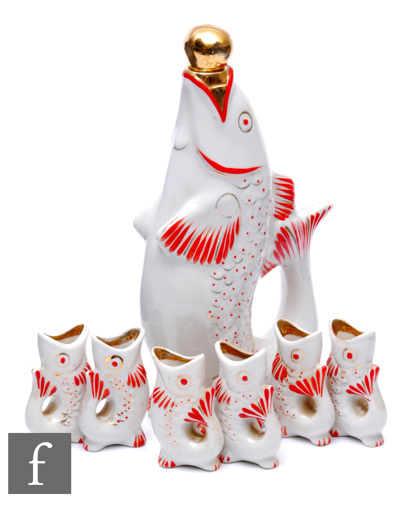 A 1960s USSR vodka decanter in the form of a fish and a set of six matching shot glasses, red and