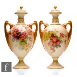 A pair of early 20th Century Royal Worcester pedestal urns and covers, shape 2158, each of slender