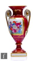 A 20th Century Dresden porcelain vase of footed pedestal form with high arched handles and a