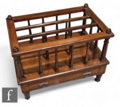 A late Victorian mahogany canterbury, three divisions with turned supports over a base drawer, on