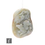 A Chinese Qing Dynasty jade pebble carving, the smooth pale green and russet stone, carved in relief