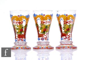 A trio of late 19th Century Bohemian small shot glasses with hand enamelled decoration, height