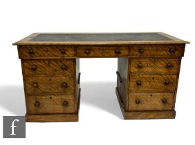 A Victorian figured mahogany kneehole writing desk fitted with three frieze drawers and three