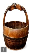 A 19th Century coopered iron bound wooden well bucket with strap and ring attachment, height 66cm.