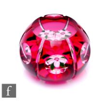 A later 20th Century John Deacons glass paperweight, of domed form, cased in ruby over clear and