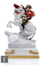 A 20th Century French porcelain figure of Napoleon on a rearing stallion with script to the rocky