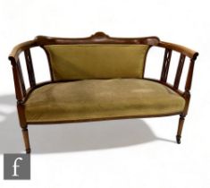 An Edwardian line inlaid mahogany two seater settee, pierced splats on turned legs to the front,