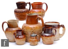 A collection of 19th Century and later salt glazed stoneware jugs with applied sprigged