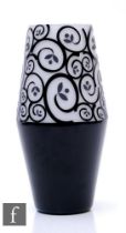 A contemporary Art Glass vase of barrel form, cased in black over white and cut to reveal a