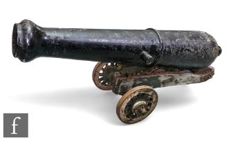 A 20th Century of earlier black painted cast iron canon, length 110cm, on wooden and iron wheel