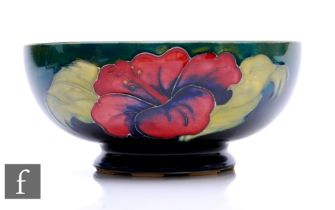 A post war Walter Moorcroft pottery bowl of footed circular form, decorated in the Hibiscus