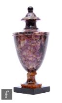 A 19th Century Blue John vase of urn shape, with fixed cover and turned pedestal base, on a slate