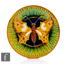 An early 20th Century English Majolica plate, decorated with a winged moth on a blue green and