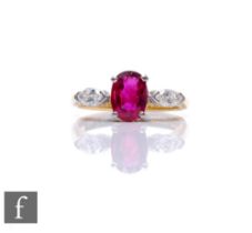 An 18ct hallmarked ruby and diamond three stone ring, central oval ruby, length 7mm, flanked by a