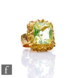 An 18ct hallmarked lemon quartz single stone ring, emerald cut claw set stone to a floral border and