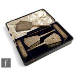 A cased Art Deco hallmarked silver six piece brush set with engine turned decoration to all,