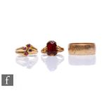 Two 9ct hallmarked rings, a wedding and a garnet single stone, with an unmarked ruby four stone
