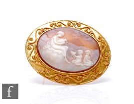 An 18ct mounted oval cameo brooch, landscape scene of a woman and children in attendance, weight