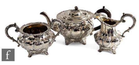 A matched hallmarked silver three piece melon shaped tea set decorated with embossed and engraved