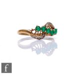 A 9ct hallmarked emerald and diamond ring, five emeralds and eight diamonds to a slight twist,