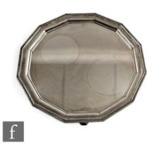 A hallmarked silver dodecagon salver of plain form with stepped border and raised on four stepped