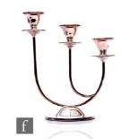 A modern hallmarked silver three light candelabra, circular base below stepped circular sconces,