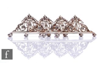 A set of four silver plated menu holders with pierced foliate decoration, raised on ball feet,