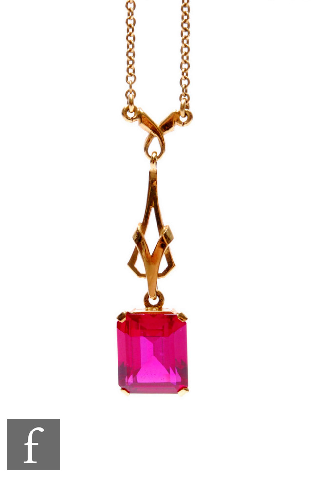An early 20th Century 9ct emerald set, red paste single stone pendant suspended from a 9ct fine