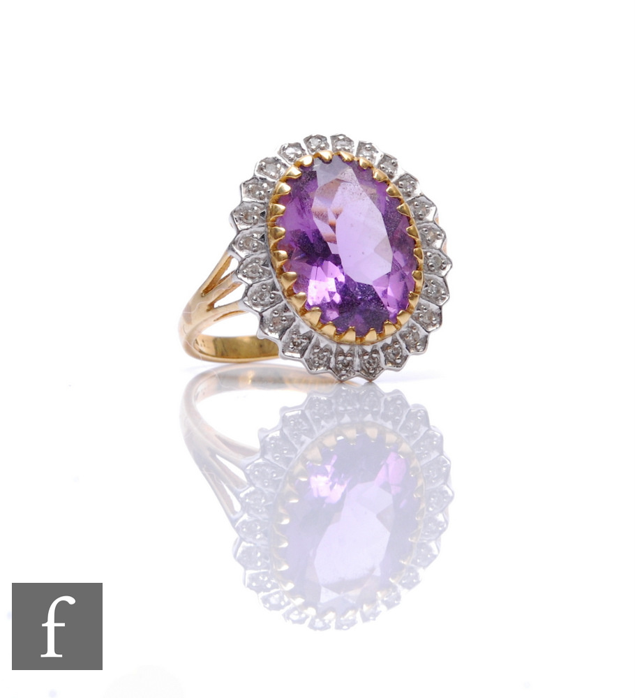 A 9ct hallmarked amethyst and diamond cluster ring, central amethyst within a border of diamonds,