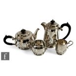 A hallmarked silver four piece tea set decorated with part relief floral frieze to base, total
