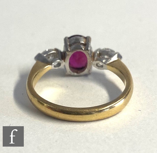 An 18ct hallmarked ruby and diamond three stone ring, central oval ruby, length 7mm, flanked by a - Image 3 of 4