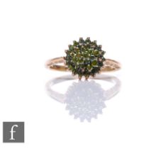 A 9ct hallmarked green diamond cluster ring, three tier stepped cluster to knife edged shoulders,
