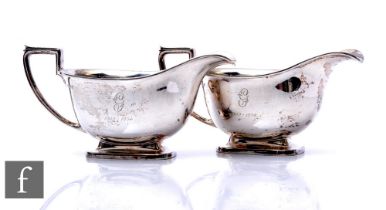 A pair of hallmarked silver pedestal sauce boats, rectangular foot below plain bodies and angular
