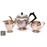 A hallmarked silver three piece pedestal tea set each with a circular stepped base below plain