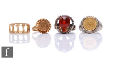 Four assorted rings, a silver example set with a Mexican Peso, a continental pierced ring, a 9ct