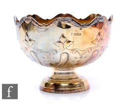 A hallmarked silver pedestal bowl with part foliate embossed decoration and gilt interior, weight