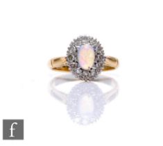 An 18ct opal and diamond cluster ring, central oval opal, length 6mm, within a border of twelve