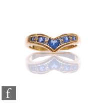 An 18ct sapphire and diamond wishbone ring with central heart shaped sapphire flanked by alternating
