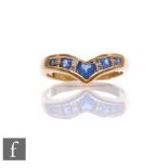 An 18ct sapphire and diamond wishbone ring with central heart shaped sapphire flanked by alternating