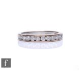 An 18ct hallmarked half eternity ring, twelve brilliant cut diamonds channel set to tapering