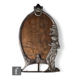 A WMF polished pewter oval easel photograph frame with the study of a standing lady playing pipes