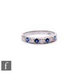An 18ct hallmarked white gold sapphire and diamond seven stone half eternity ring, weight 3.9g, ring