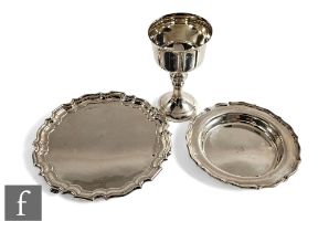 Three items of modern hallmarked silver, a card waiter, a bottle coaster and a goblet, total