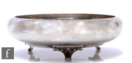 A hallmarked silver circular shallow, roll top bowl of plain form raised on three scroll feet,