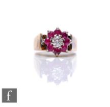 An 18ct hallmarked ruby and diamond cluster ring, central diamond within an eight stone border,
