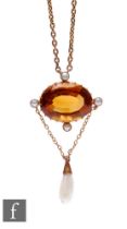 A 9ct citrine single stone pendant, oval claw set stone within a border of four seed pearls and