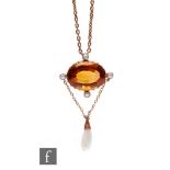 A 9ct citrine single stone pendant, oval claw set stone within a border of four seed pearls and